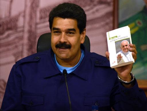 El presidente venezolano Nicolás Maduro enseña el 5 de marzo de 2014 en Caracas un libro sobre el papa Francisco durante una conferencia de prensa (AFP/Archivos | Juan Barreto)