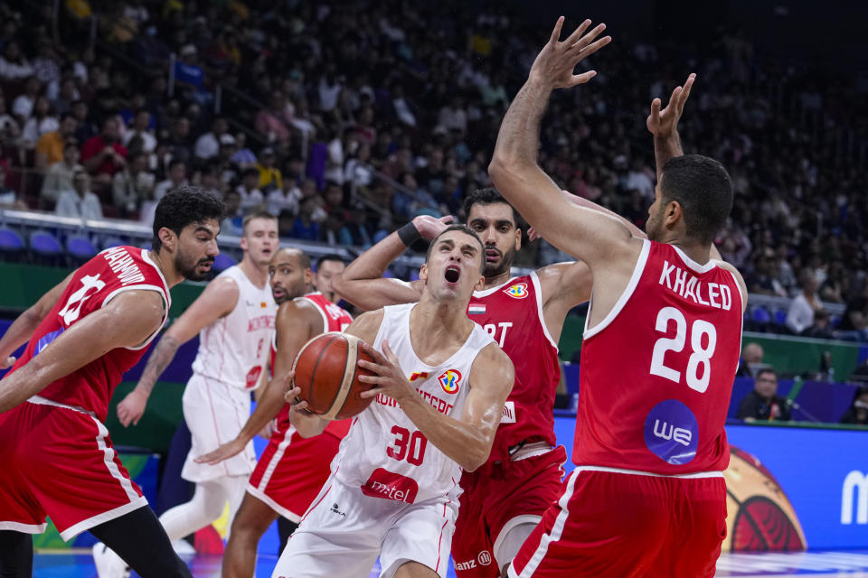 Montenegro guard Petar Popovic (30) looks to shoot over Egypt forward Khaled Abdelgawad (28) during the first half of a Basketball World Cup group C match in Manila, Philippines Sunday, Aug. 27, 2023. (AP Photo/Michael Conroy)