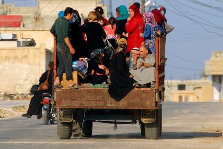 Civilians sit on a pick-up truck with their belongings in Taybat al Imam town after rebel fighters from the hardline jihadist Jund al-Aqsa advanced in the town in Hama province, Syria August 31, 2016. REUTERS/Ammar Abdullah