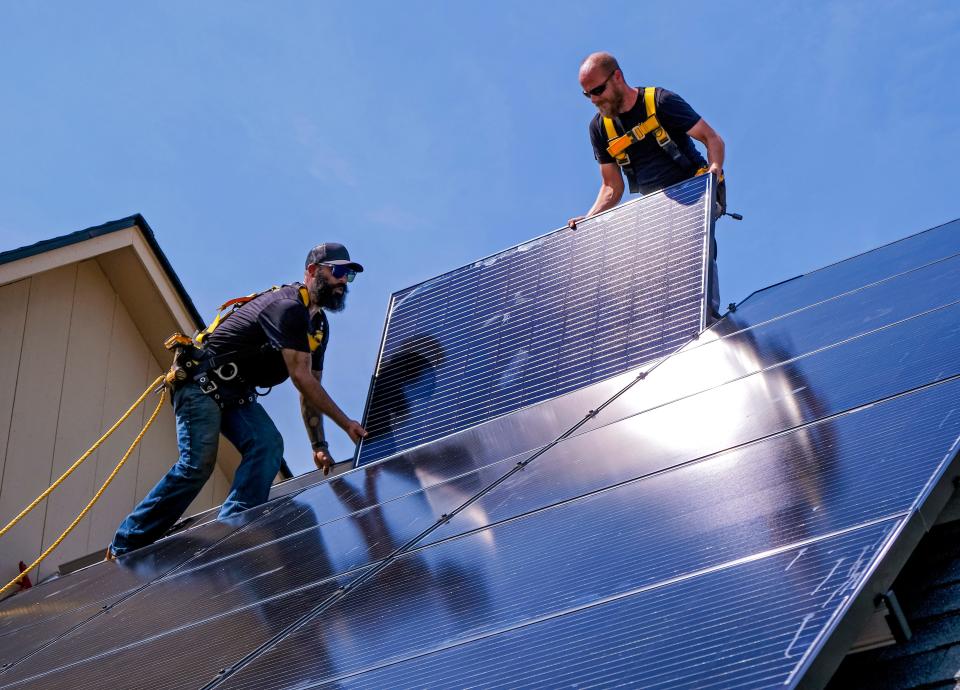 Nathan McDaniel, left, and Frank Caldwell install solar panels for EightTwenty, a solar energy company in Oklahoma City.