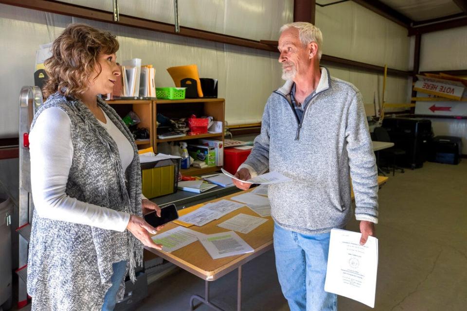 Torrance County manager Janice Barela, left, talks with Stephen Garrett, independent candidate for county commissioner, during a ballot-counting machines testing in Estancia, N.M., Sept. 29, 2022.