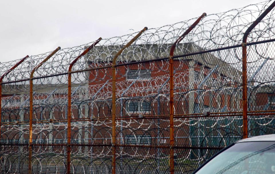 This March 16, 2011 file photo shows a barbed wire fence outside inmate housing on New York's Rikers Island correctional facility in New York.