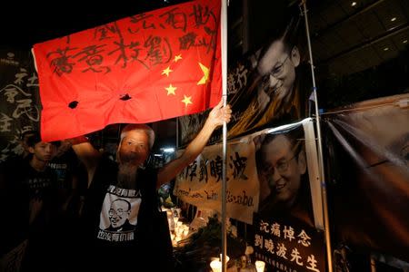 A protester holds a defaced Chinese national flag with words "fascist kills Liu Xiaobo", as he mourns the death of Nobel laureate Liu Xiaobo, outside China's Liaison Office in Hong Kong, China July 15, 2017. REUTERS/Bobby Yip