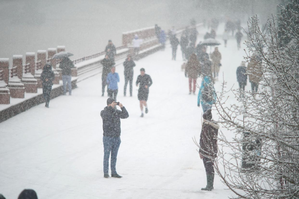 <p>People walking in the snow in Battersea Park on Sunday</p> (PA)