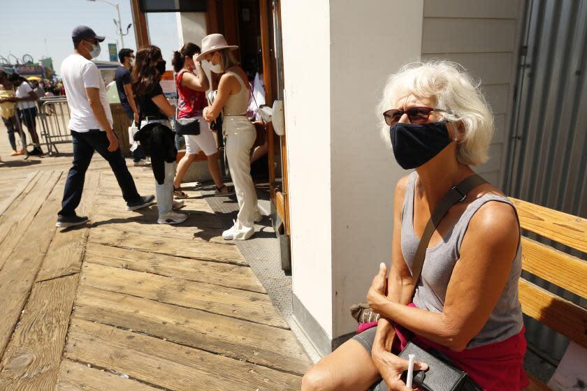 SANTA MONIA, CA - MARCH 29: Betsy, 66, visiting from Florida talks about the differences regarding Spring break as she visits the Santa Monica Pier Monday. Santa Monica Pier and Promenade on Monday, March 29, 2021 in Santa Monia, CA. (Al Seib / Los Angeles Times).