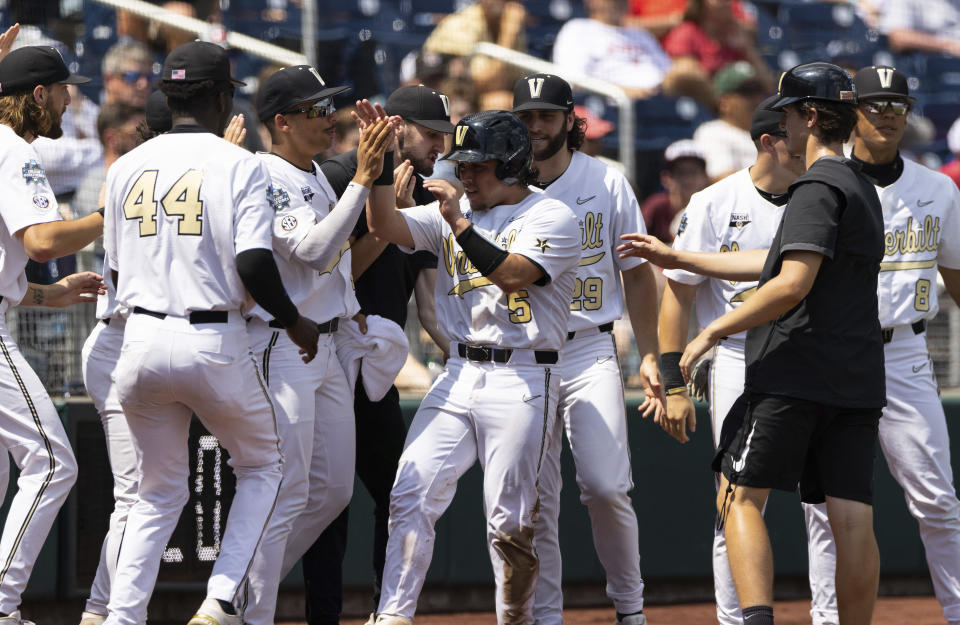 Vanderbilt's CJ Rodriguez (5) celebrates with teammates after scoring off a wild pitch from North Carolina State in the fourth inning during a baseball game in the College World Series, Friday, June 25, 2021, at TD Ameritrade Park in Omaha, Neb. (AP Photo/Rebecca S. Gratz)