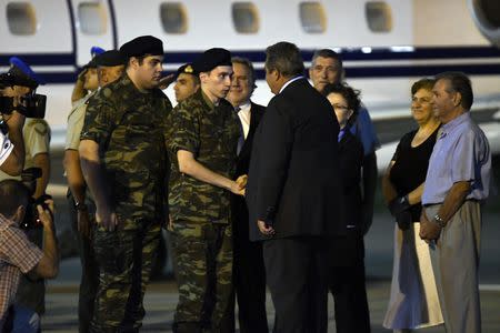 Angelos Mitretodis (C) and Dimitris Kouklatzis (L), two Greek soldiers who were detained in Turkey after crossing the border, are welcomed by Greek Defense Minister Panos Kammenos after being released, at the airport of Thessaloniki, Greece, August 15, 2018. REUTERS/Alexandros Avramidis