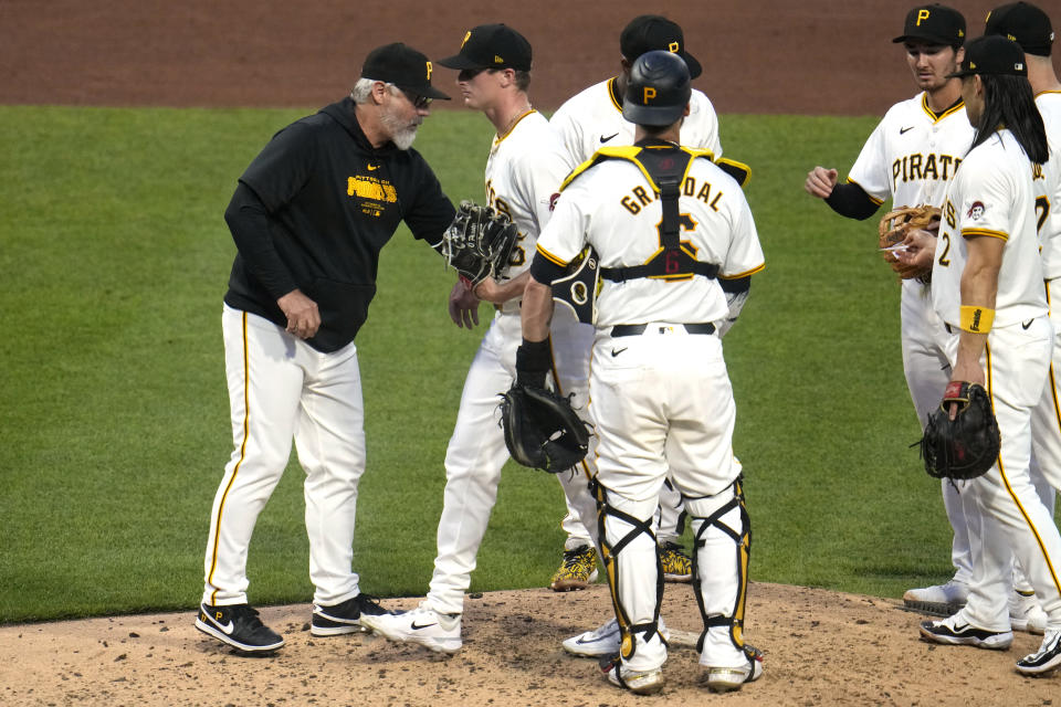 Pittsburgh Pirates pitcher Quinn Priester, second from left, walks off the mound after handing the ball to manager Derek Shelton, left, during the fifth inning of the team's baseball game against the Los Angeles Angels in Pittsburgh, Tuesday, May 7, 2024. (AP Photo/Gene J. Puskar)