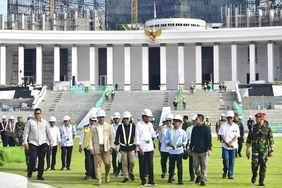 In this photo released by Indonesian Presidential Palace, Indonesian President Joko Widodo, center, inspects the presidential palace construction site at the new capital city Nusantara in Penajam Paser Utara, East Kalimantan, Indonesia, Wednesday, June 5, 2024.(Vico/Indonesian President Palace via AP)