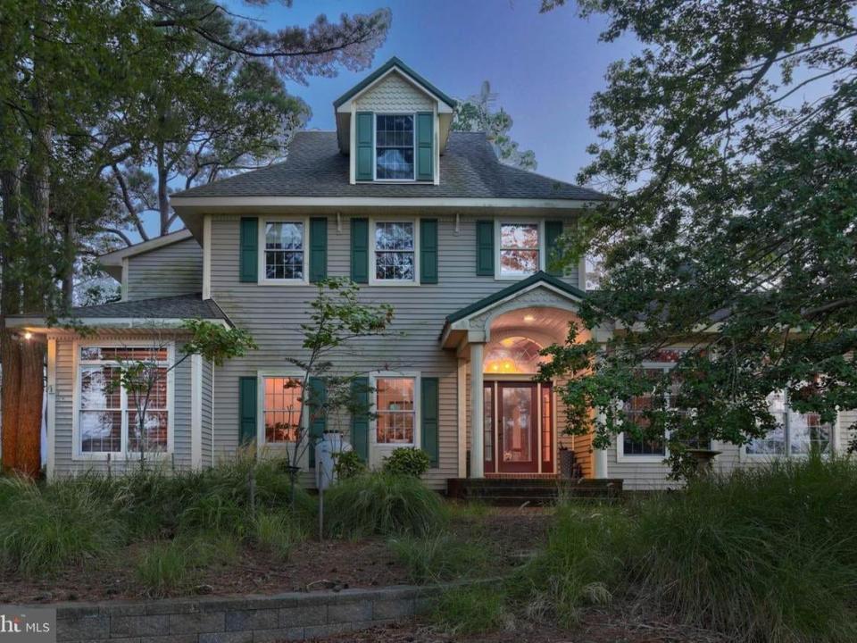 two story home with trees and bushes around it in Delaware