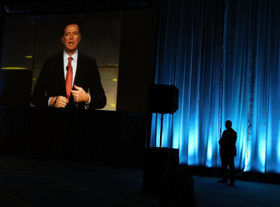 FBI Director James Comey is seen on a monitor speaking during a government symposium on cyber security, on August 30, 2016 in Washington, D.C. (Photo: Mark Wilson/Getty Images)