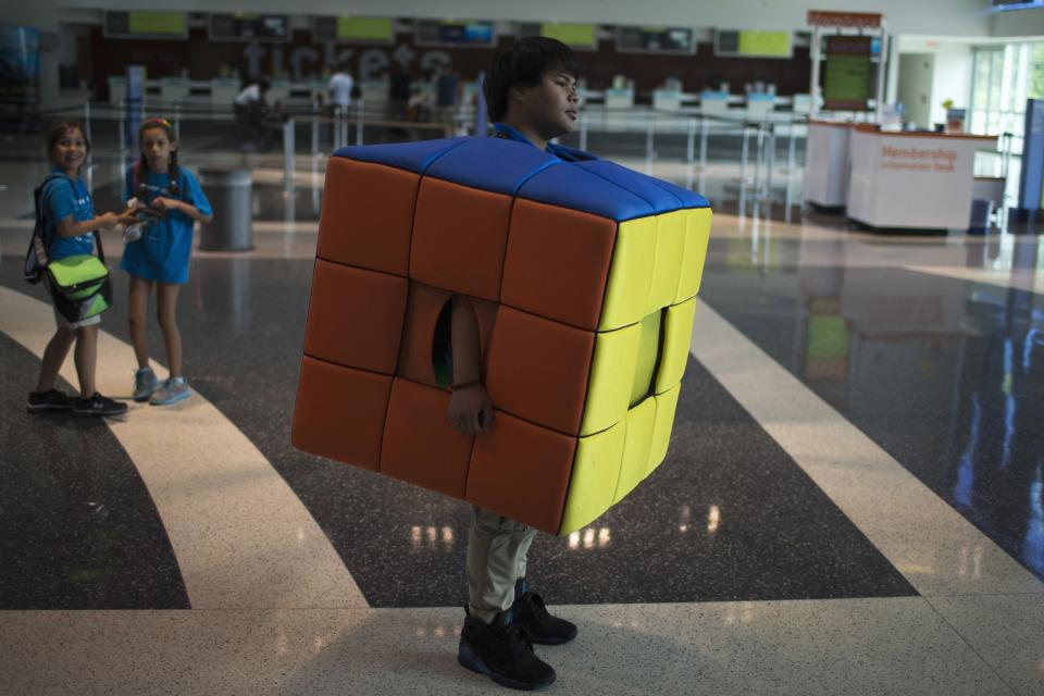 A volunteer wears a costume dressed as a Rubik's Cube during the National Rubik's Cube Championship at Liberty Science Center in Jersey City