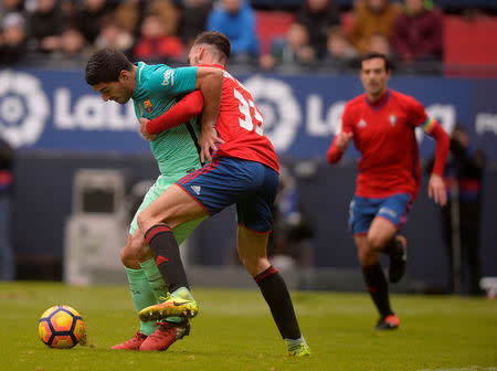Football Soccer - Osasuna v Barcelona - Spanish La Liga Santander - El Sadar, Pamplona, Spain - 10/12/2016 Barcelona's Luis Suarez fights for the ball with Osasuna's Ivan Marquez. REUTERS/Vincent West