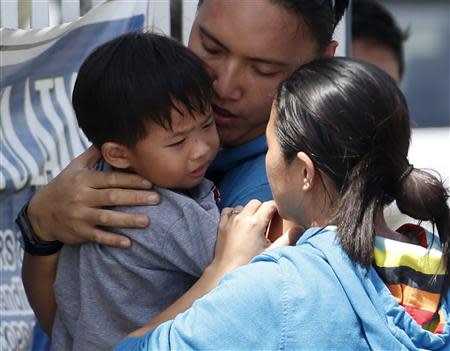 A two-year-old boy who was freed along with dozens of residents taken hostage for a week by the Muslim rebels of Moro National Liberation Front (MNLF) is reunited with his parents, at a police camp in Zamboanga city in southern Philippines September 17, 2013. REUTERS/Erik De Castro