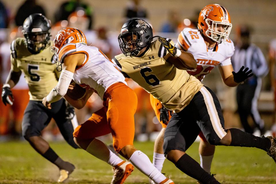 Buchholz Bobcats defensive end Gavin Hill (6) tackles University Titans quarterback Tazz Figueroa (9) during the first half at Citizens Field in Gainesville on Nov. 19, 2021. Hill committed to the University of Florida on June 25.