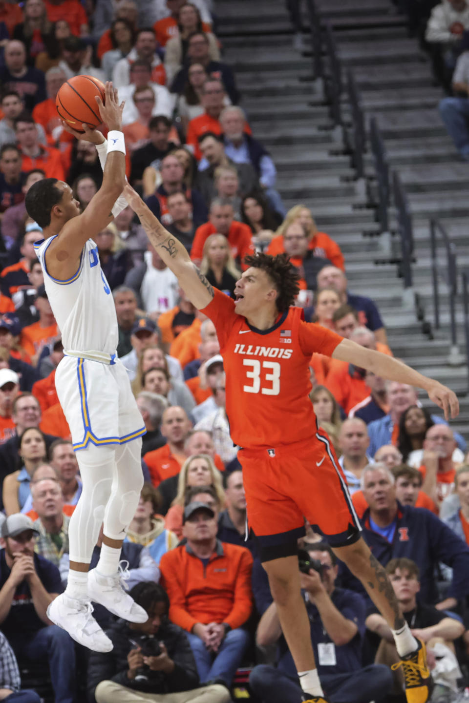 UCLA guard Amari Bailey shoots over Illinois forward Coleman Hawkins (33) during the first half of an NCAA college basketball game Friday, Nov. 18, 2022, in Las Vegas. (AP Photo/Chase Stevens)