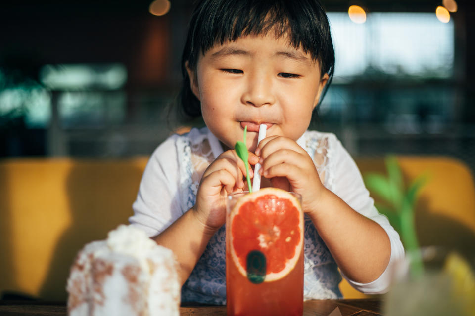 Little girl girl drinking grapefruit juice  at home. Ulsan, South Korea.