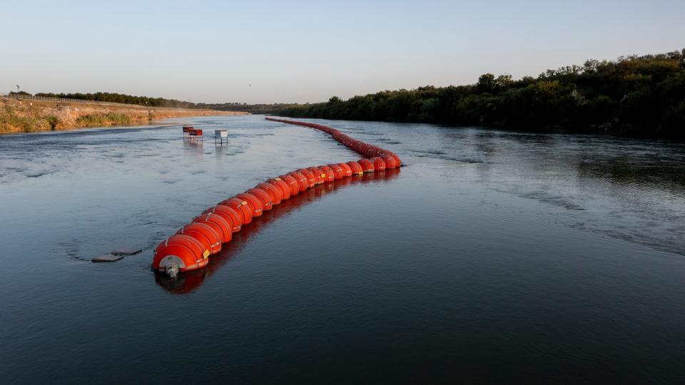 Boyas puestas en la frontera internacional entre México y los Estados Unidos fueron colocadas por el Estado de Texas en el Río Bravo como una medida para prevenir que los migrantes en  busca de asilo crucen hacia Eagle Pass, Texas desde Piedras Negrss, Coahuila, México. En esta foto desde un drone Eagle Pass, Texas está del lsdo izquierdo del cuadro, mirando río abajo hacia el este.