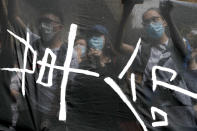 Supporters of Hong Kong jailed activist Edward Leung hold banner with the words "Revolution" outside the High Court in Hong Kong, Wednesday, Oct. 9, 2019. Last year, Leung was sentenced to six years in prison for his part in a violent nightlong clash with police over illegal street food hawkers two years ago. (AP Photo/Kin Cheung)