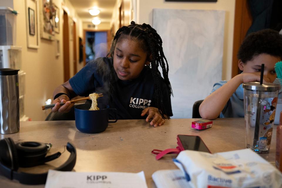 Arius Wooten, 8, right, and Naomi Wooten, 11, eat ramen noodles in their home on the Near East Side.