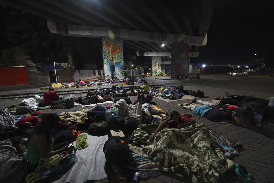 Migrants sleep outside a train station as they wait for the arrival of a northbound freight train, in Irapuato, Mexico, Friday, Sept. 22, 2023. (AP Photo/Marco Ugarte)