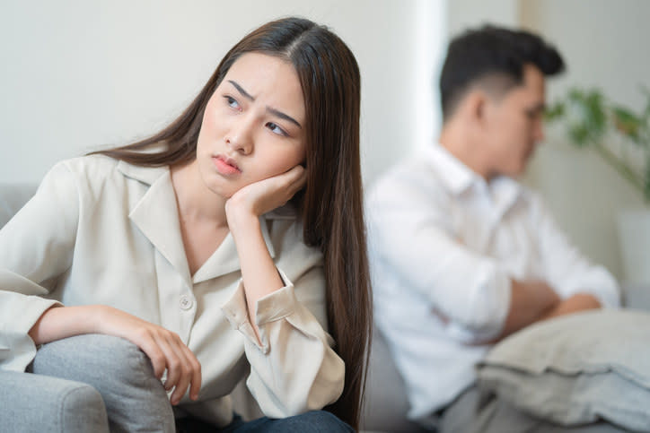 Person sitting on the couch away from their partner