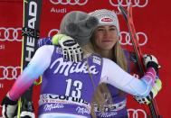 FILE - United States' Mikaela Shiffrin, third place in an alpine ski, women's World Cup downhill, right, is hugged by second-placed United States' Lindsey Vonn, in Cortina D'Ampezzo, Italy, In this Friday, Jan. 19, 2018 file photo. Mikaela Shiffrin has had a World Cup skiing career like no other woman. Shiffrin raced to a record-breaking 83rd win Tuesday, Jan. 24, 2023. (AP Photo/Alessandro Trovati, File)