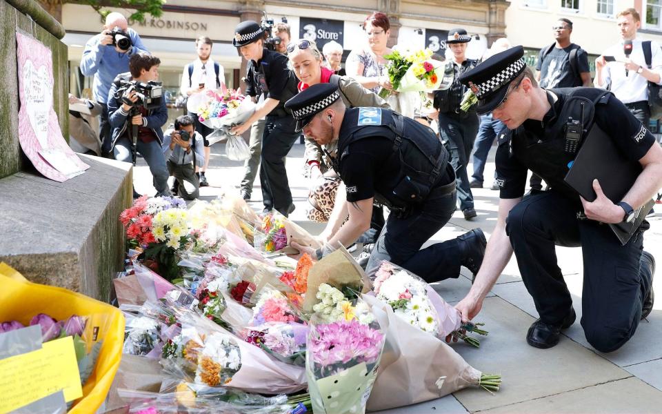 Flowers are left in St Ann's Square, Manchester - Credit: PA