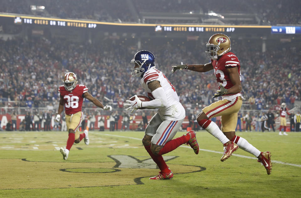 New York Giants wide receiver Odell Beckham Jr., center, scores in front of San Francisco 49ers cornerback Ahkello Witherspoon, right, and defensive back Antone Exum (38) during the second half of an NFL football game in Santa Clara, Calif., Monday, Nov. 12, 2018. (AP Photo/Tony Avelar)