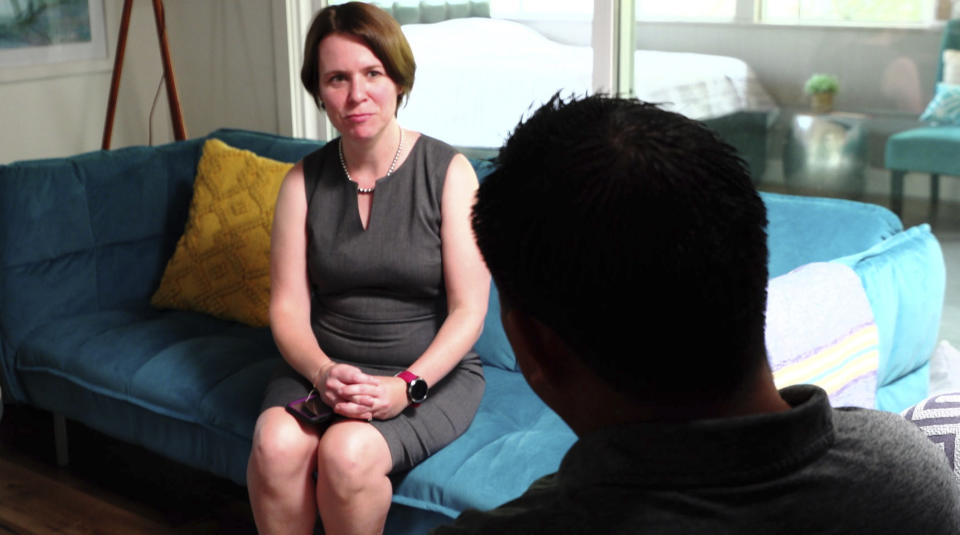 In this Aug. 7, 2019 image made from video, attorney Michelle Lapointe speaks with her client, a Guatemalan immigrant, in Santa Ana, Calif. The father is preparing to sue the federal government, alleging his 8-year-old boy was sexually molested in a foster care home funded by the U.S. Health and Human Services agency. He says he is still struggling to soothe his son’s lasting nightmares, and that the 3rd grader, once talkative and outgoing, is now withdrawn and frequently says he wants to leave this world. (AP Photo/Krysta Fauria)