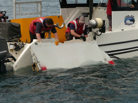 A Boeing 777 flaperon cut down to match the one from flight MH370 found on Reunion island off the coast of Africa in 2015, is lowered into water to discover its drift characteristics by Commonwealth Scientific and Industrial Research Organisation researchers in Tasmania, Australia, in this handout image taken March 23, 2017. CSIRO/Handout via REUTERS