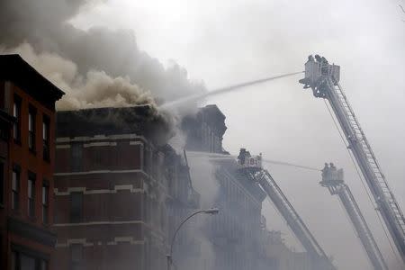 New York City Fire Department firefighters battle fire at the site of a residential apartment building in New York City's East Village neighborhood, March 26, 2015. REUTERS/Mike Segar