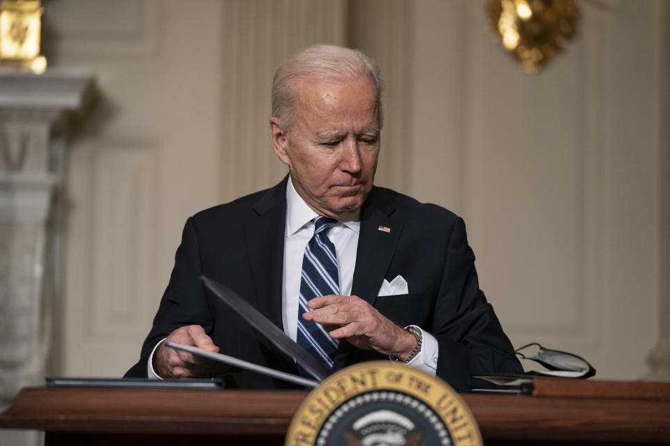 FILE - In this Jan. 27, 2021, file photo President Joe Biden signs a series of executive orders on climate change, in the State Dining Room of the White House in Washington. In a flurry of executive actions in his first eight days in office, the president is trying to steer the U.S. economy from one fueled by fossils to one that no longer puts additional heat-trapping gases into the air by 2050. (AP Photo/Evan Vucci, File)