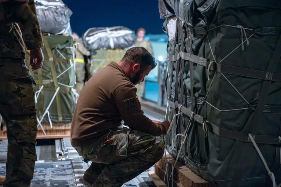 US Air Force airmen and US Army soldiers prepare bundles of humanitarian assistance for airdrop aboard a C-130J Super Hercules.