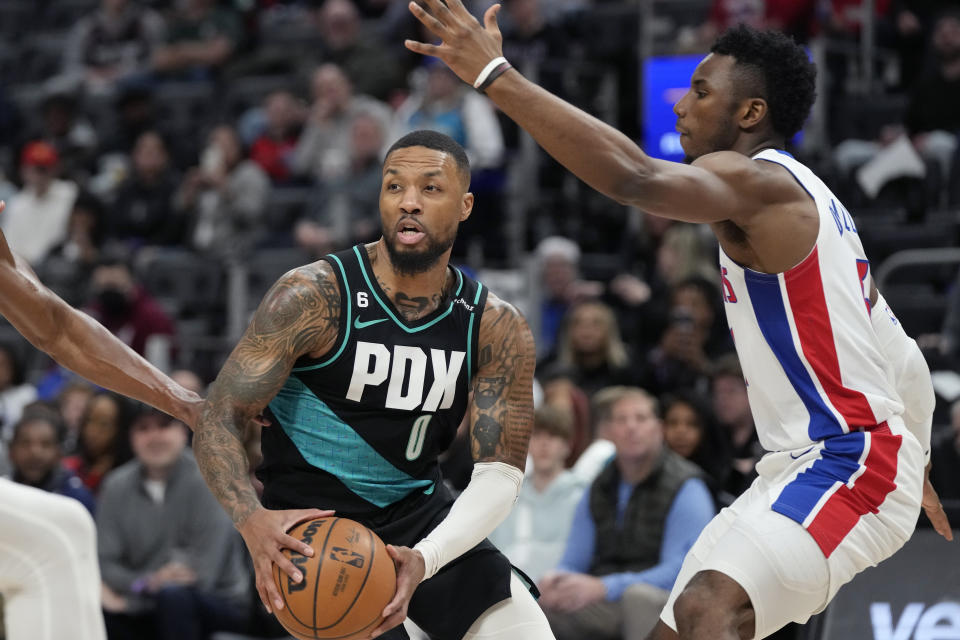 Portland Trail Blazers guard Damian Lillard looks to pass as Detroit Pistons guard Hamidou Diallo (6) defends during the first half of an NBA basketball game against the Detroit Pistons, Monday, March 6, 2023, in Detroit. (AP Photo/Carlos Osorio)