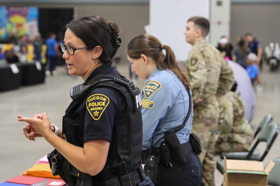 Officer Melissa Ayun, who recruits for Tucson Police Department, speaks at the department's booth at the Kidz Expo Back to School, hosted by the Arizona Bilingual Newspaper, on July 23, 2022, at the Tucson Convention Center. (Photo by Kate Heston/News21)