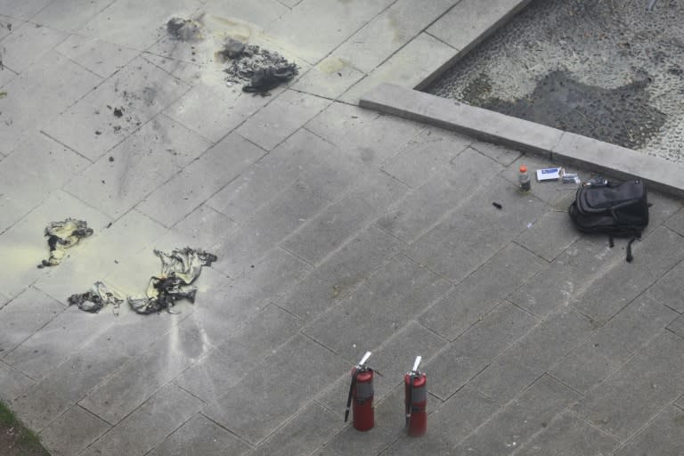 Des extincteurs et un sac à dos sur le sol du square en face du tribunal de New York où un homme a tenté de s'immoler par le feu, 19 avril 2024 (ANGELA WEISS)