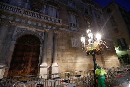 A worker waters the flowers outside the Generalitat Palace, the Catalan regional government headquarter in Barcelona, Spain, October 30, 2017. REUTERS/Yves Herman