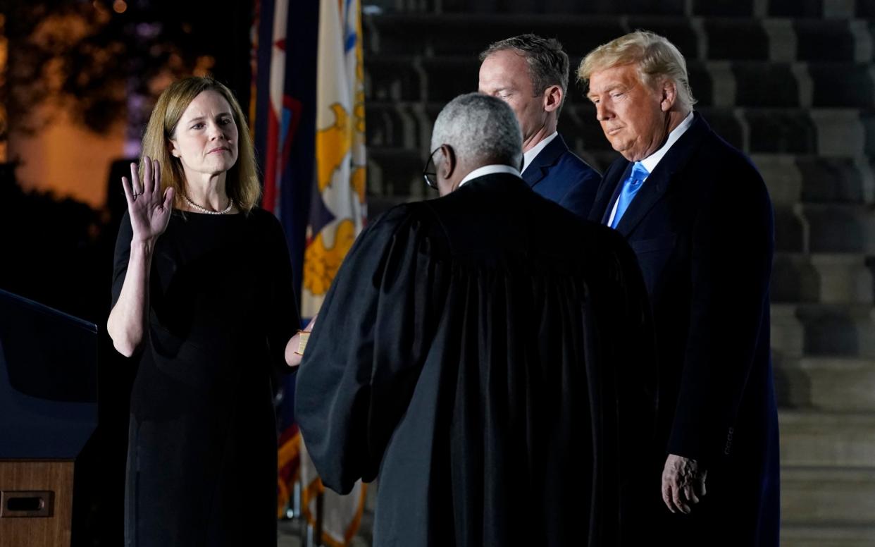 Amy Coney Barrett takes the oath beside Donald Trump at the White House - AP