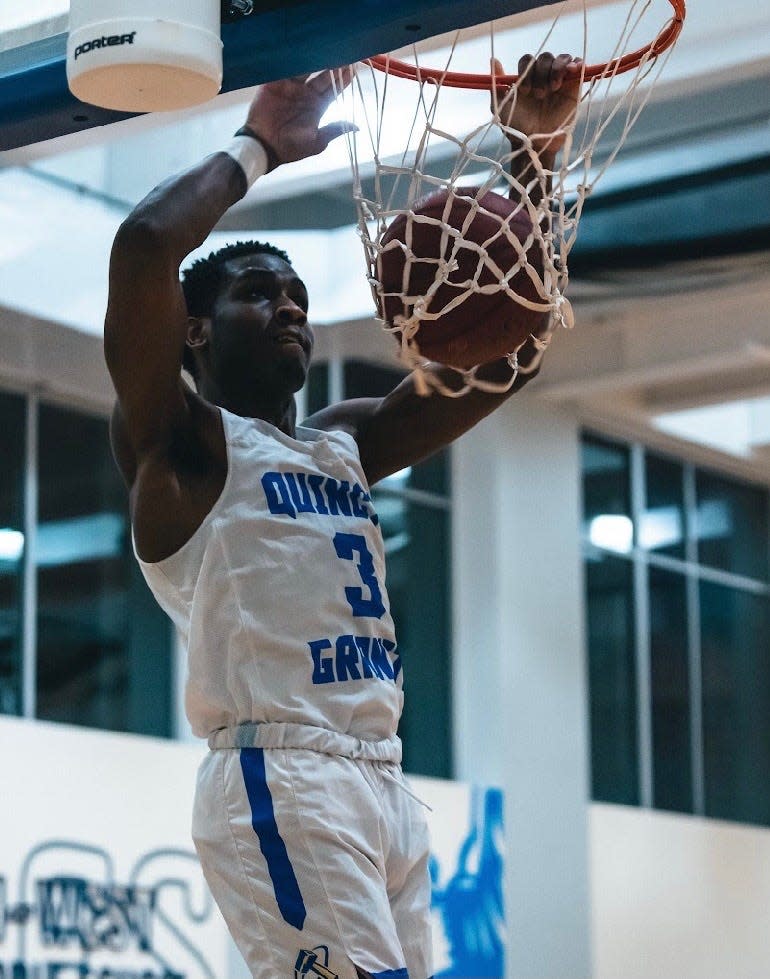 Quincy College's Damani Scott throws down a dunk.