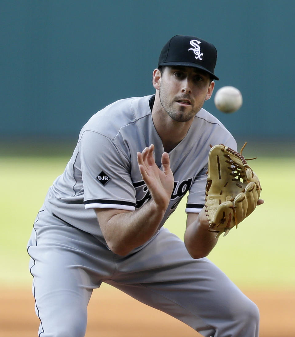 Chicago White Sox starting pitcher Scott Carroll catches a ball hit by Cleveland Indians' Michael Bourn in the first inning of a baseball game, Saturday, May 3, 2014, in Cleveland. Bourn was out at first base. (AP Photo/Tony Dejak)