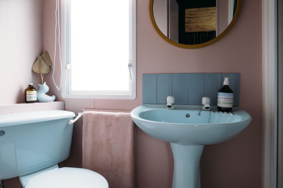 AFTER: The original floor was covered with terrazzo-like Marmoleum, while pastel-colored bathroom fixtures (“destined for landfill, but we thought they were so charming,” says Anna) replaced the original ones for a retro look.