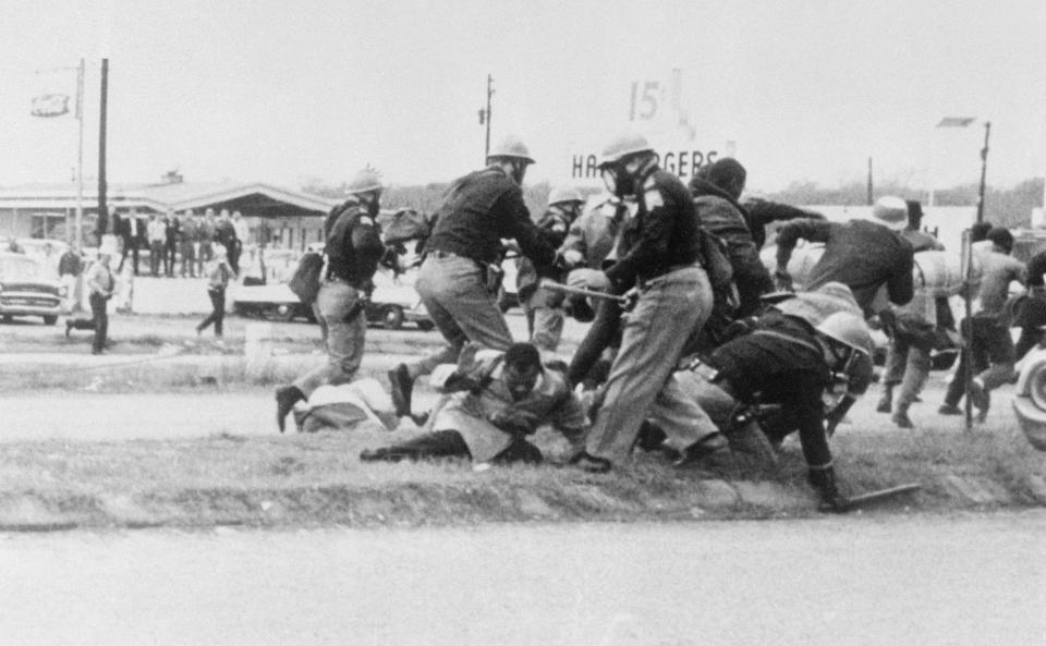 John Lewis (center, in the light coat) attempts to ward off a blow from a state trooper as civil rights activists marched from Selma to Montgomery, Alabama, on March 7, 1965. Lewis was later admitted to a local hospital; he had a fractured skull.  (Photo: Bettmann via Getty Images)