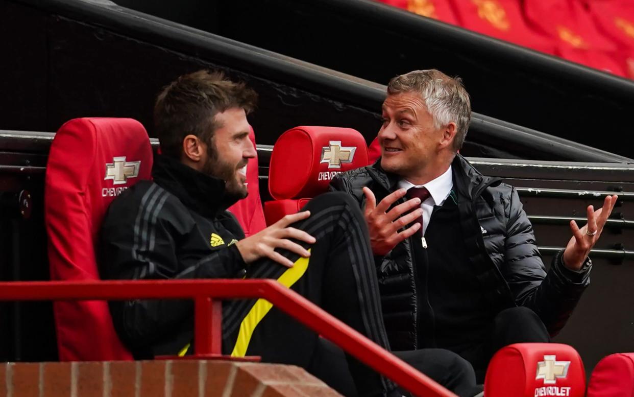 Ole Gunnar Solskjaer talks with Michael Carrick - AFP