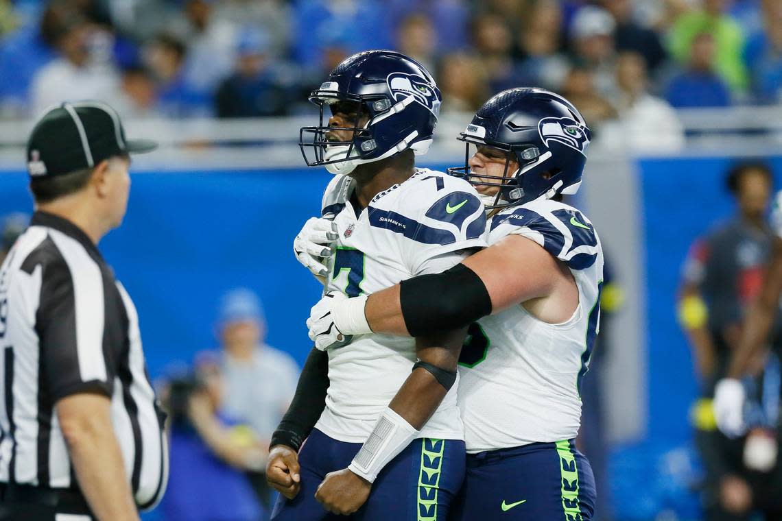 Seattle Seahawks quarterback Geno Smith is hugged by guard Austin Blythe, right, after Smith rushed for an 8-yard touchdown during the first half of an NFL football game against the Detroit Lions, Sunday, Oct. 2, 2022, in Detroit. (AP Photo/Duane Burleson)