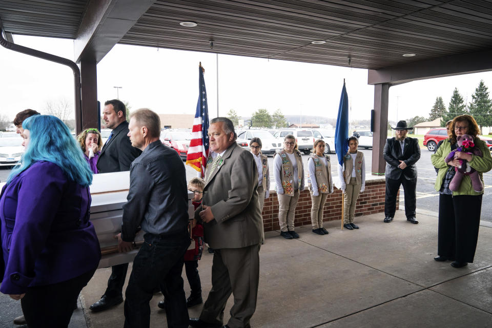 Family members of Sara Jo Schneider and her daughter Haylee Hickle carry the single casket containing both mother and daughter from the Chippewa Valley Bible Church after their funeral Thursday, Nov. 8, 2016 in Chippewa Falls, Minn.. Behind them are members of the Spirit of Nebraska Girl Scout Honor Guard. Five girls came from different troops in Nebraska. Woman holding stuffed animal on the right of casket is Judy Schneider, mother of Sara Schneider, and grandmother to Haylee Hickle. (Glen Stubbe/Star Tribune via AP)