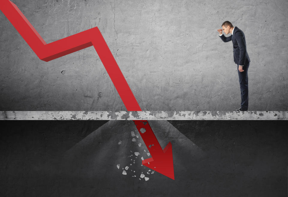 Businessman looking at red line going through the floor