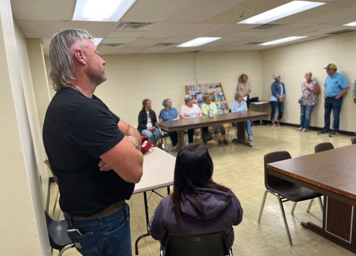 Jared Bossly stands with his arms crossed as fellow landowners stand with him in solidarity in the Brown County Courthouse basement after a court hearing on May 31, 2023.