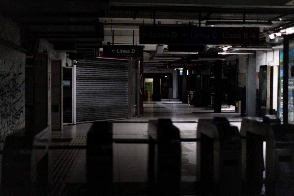 Hallways of Buenos Aires's subway are lit only by emergency lights during a blackout, in Buenos Aires, Argentina, Sunday, June 16, 2019. Argentina and Uruguay were working frantically to return power on Sunday, after a massive power failure left large swaths of the South American countries in the dark. (AP Photo/Tomas F. Cuesta)