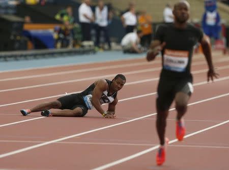 Yohan Blake of Jamaica falls injured in the men's 100m during the IAAF Diamond League athletics meeting at Hampden Park in Glasgow July 11, 2014. REUTERS/Phil Noble